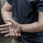 Elementary Teacher’s Arrest Shocks Texas School Person in handcuffs with hands behind back.