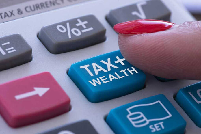 Finger pressing calculator tax and wealth button