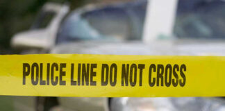 Yellow police tape in front of a car.