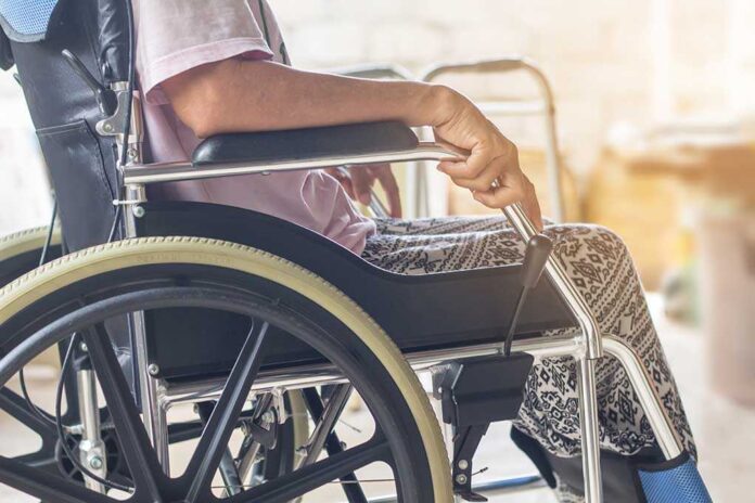 Close-up of a person sitting in a wheelchair with patterned pants