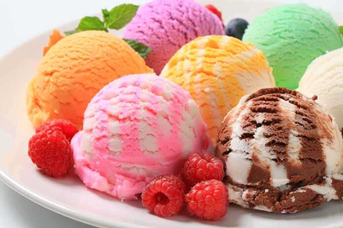 A plate of colorful ice cream scoops with fresh raspberries and mint leaves