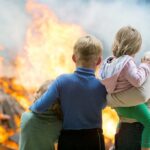 Arsonist Nabbed For L.A. Wildfire — FINALLY! A family watching a large fire outdoors with children in their arms