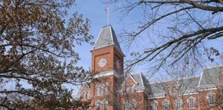 Historic university building with students walking in front during autumn