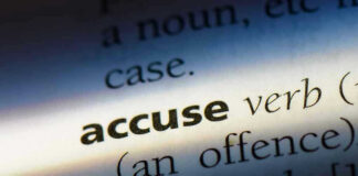 Close-up dictionary definition of accuse underlined.