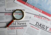 Newspapers with Cyber Attack headlines and a magnifying glass.