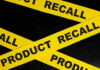 Yellow tape with product recall text on black background.