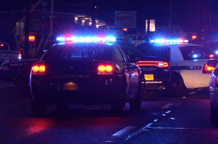 shutterstock_123247690.jpg Police cars with flashing lights at a nighttime scene near a motel