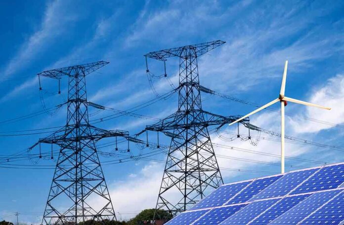 Solar panels and a wind turbine with power lines against a blue sky