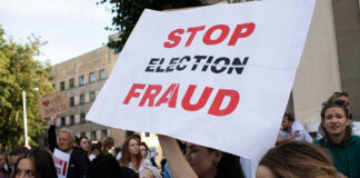 People holding Stop Election Fraud protest signs.