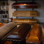 Wooden coffins and urns displayed in a showroom.