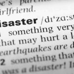Close-up of a dictionary page showing the definition of the word 'disaster'