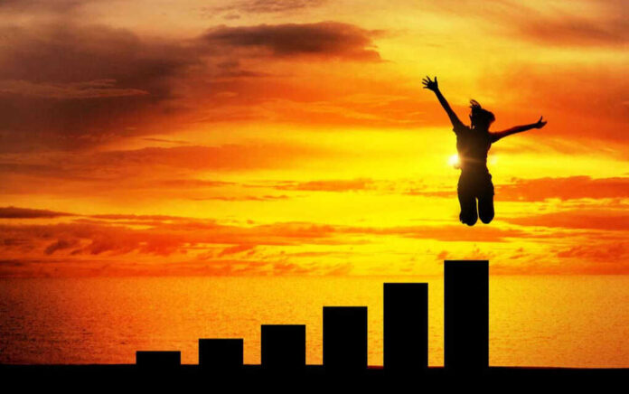 505195903 Silhouette jumping above bar chart at sunset.