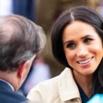 $100M Deal Crumbles—Markle Out A woman smiling while engaging in conversation at an outdoor event