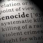 Close-up of the word Genocide in a dictionary