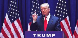 Donald Trump delivering a speech at a podium with American flags in the background
