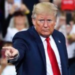 Trump UNLEASHES BRUTAL Ultimatum Against Defense Giant A man in a suit pointing during a speech at a rally
