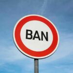 Faith CRACKDOWN Looms Over South Korea A road sign displaying the word 'BAN' against a blue sky