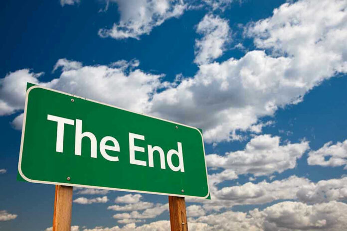 Green sign with white text The End sky background