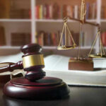 Gavel, law book, and scales in a library.