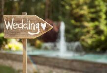 Wooden sign pointing towards a wedding venue
