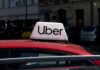 Uber taxi sign on the roof of a red car