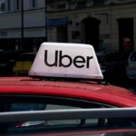 Uber taxi sign on the roof of a red car