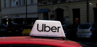 Uber taxi sign on the roof of a red car