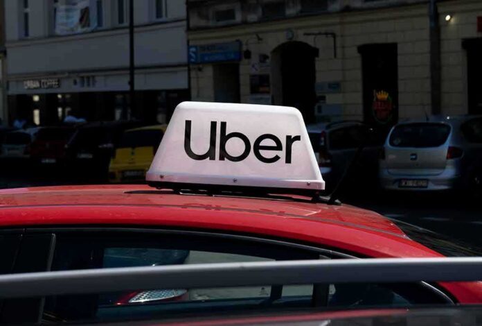 Uber taxi sign on the roof of a red car