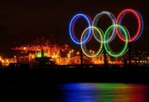 Israel’s Olympians VIOLATED—What Happens Next? Illuminated Olympic rings displayed at night over a harbor