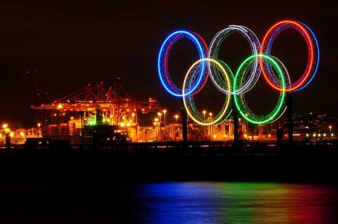 shutterstock_40801198.jpg Illuminated Olympic rings displayed at night over a harbor