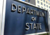 State Department: LEAVE NOW! Department of State sign in front of building.