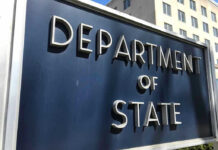 State Department: LEAVE NOW! Department of State sign in front of building.