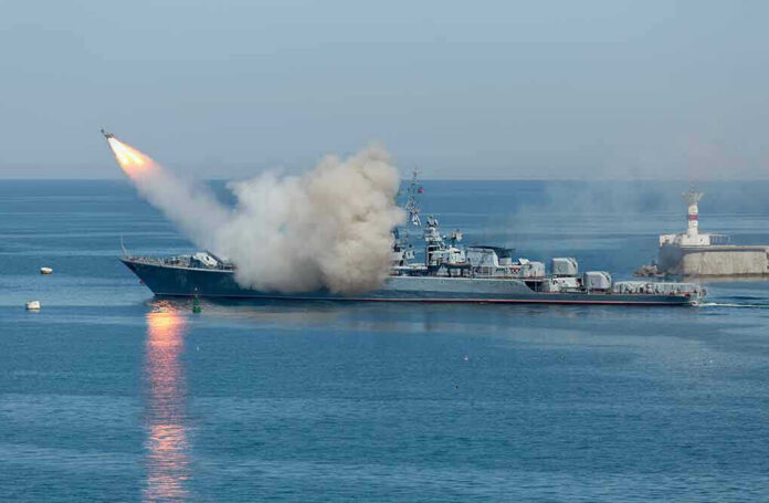 Warship firing missile in the sea.