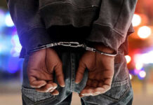 CLEAN DUI–Celebrity Booked ANYWAY Person in handcuffs with colorful lights in background.
