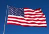 Waving American flag against a clear blue sky