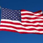 Waving American flag against a clear blue sky