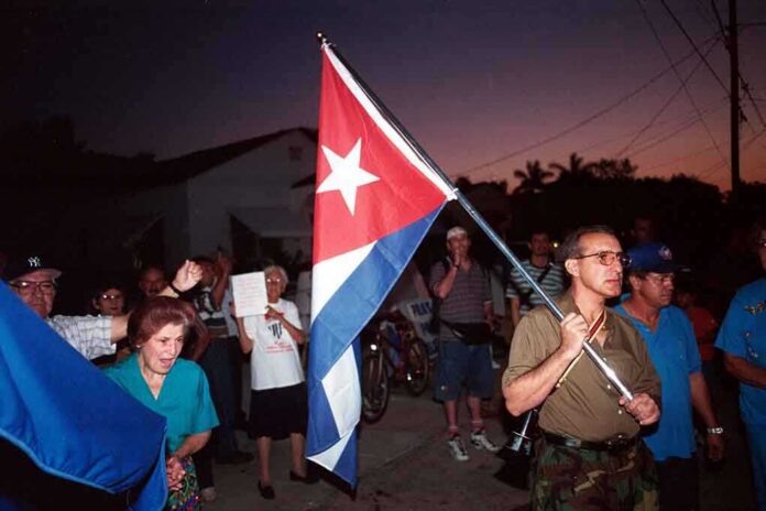 shutterstock_37307824.jpg A group of people participating in a protest march holding a Cuban flag