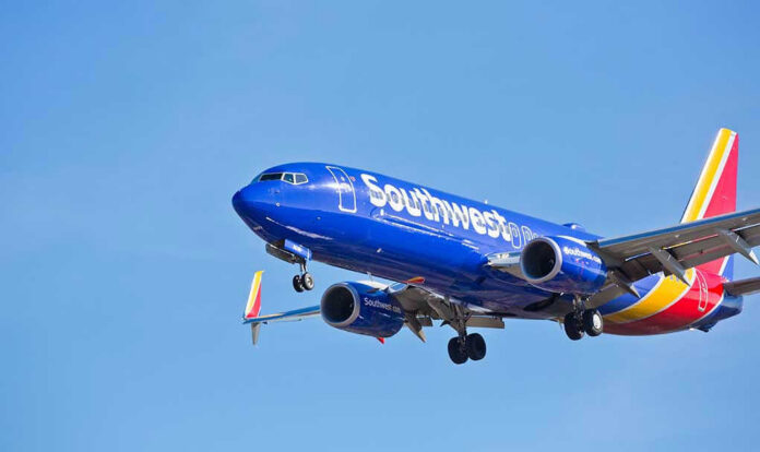 Southwest Airlines plane flying in blue sky.