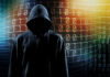 Hooded figure with binary code background.