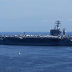 A large aircraft carrier sailing in the ocean