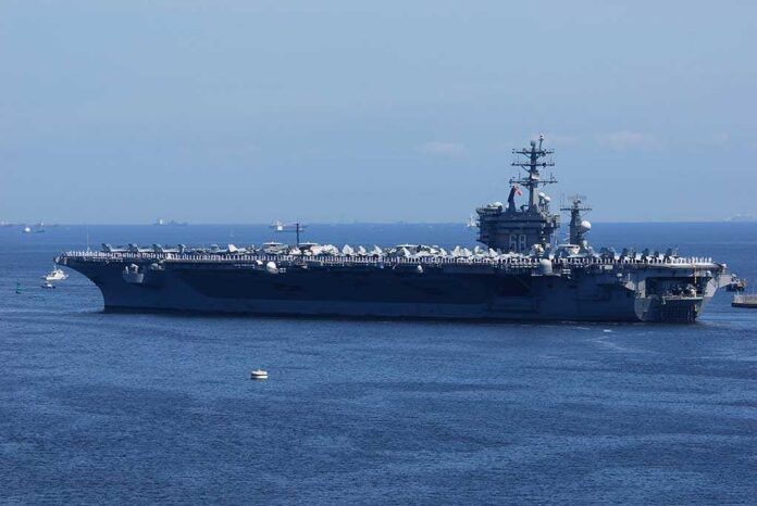 shutterstock_1340097212 (1).jpg A large aircraft carrier sailing in the ocean