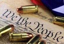Close-up of bullets surrounding a historical document with the phrase We the People
