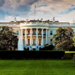 The White House surrounded by greenery and a fountain in the foreground