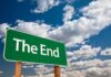A green road sign displaying the words The End against a cloudy sky
