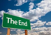A green road sign displaying the words The End against a cloudy sky