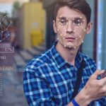 Young man using a smartphone with face recognition overlay