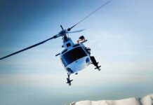 Shocking Rescue: Toddler Trapped On Mountain A helicopter flying over a mountainous landscape against a blue sky