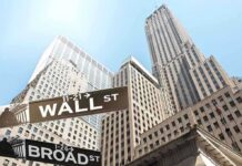 Street signs for Wall Street and Broad Street with skyscrapers in the background