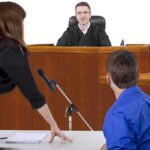 A judge presiding over a courtroom with a lawyer speaking to the court