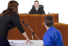 A judge presiding over a courtroom with a lawyer speaking to the court